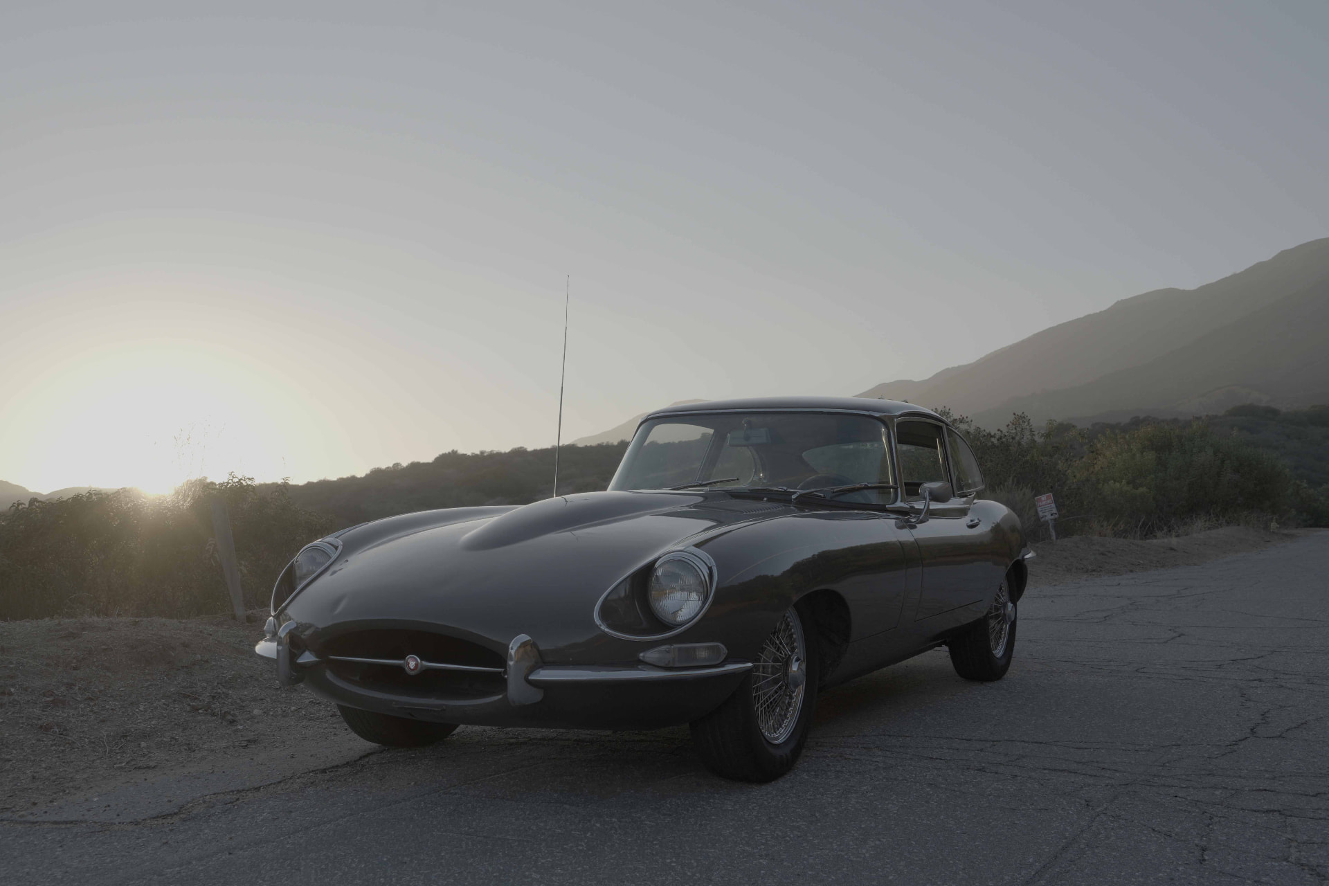 Classic sports car on an empty coastal road at first light