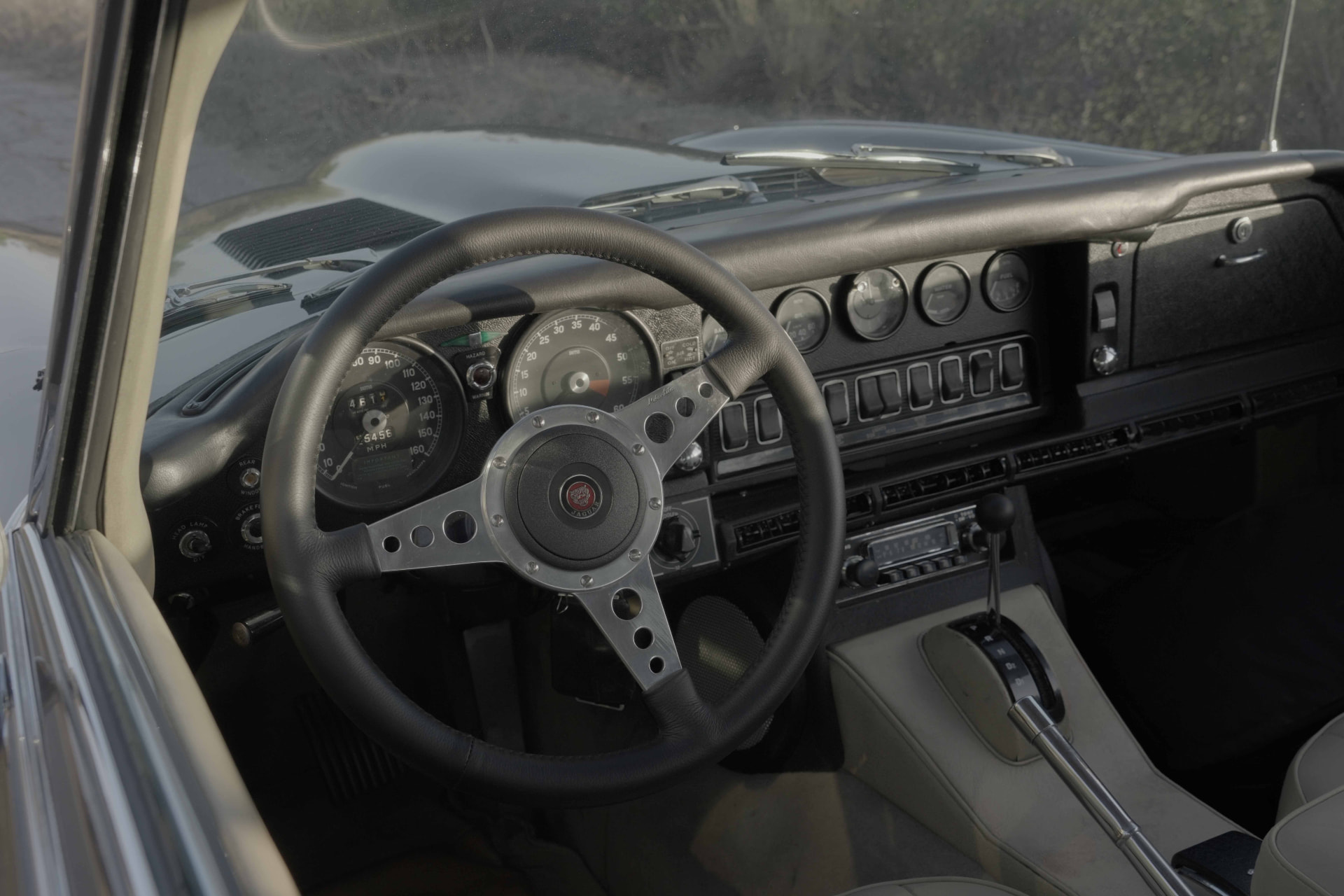 Leather-rimmed steering wheel and analogue gauges in a 1968 Jaguar E-Type